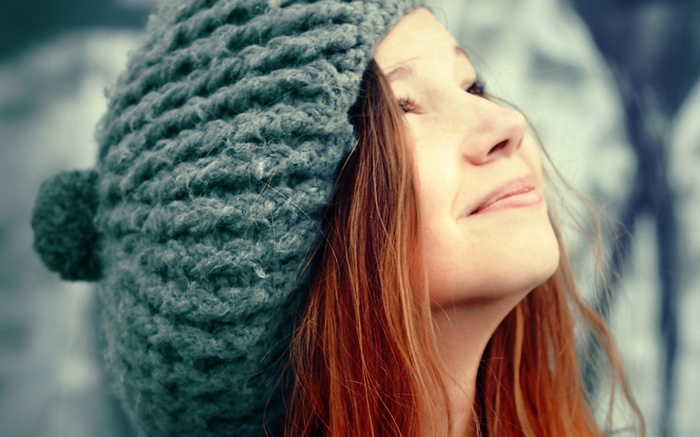 Woman wearing a knitted hat looking up