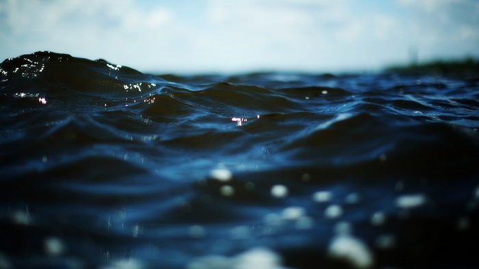 Dark Blue Sea Waves with Bokeh and Clouds