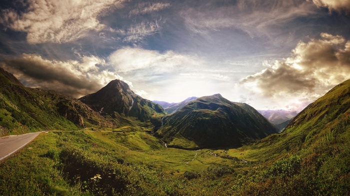 Mountain valley with a road and dramatic clouds