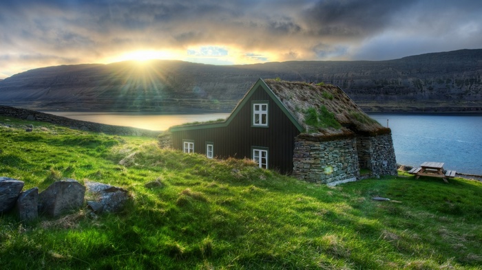 Traditional house with grass roof by a fjord in Iceland