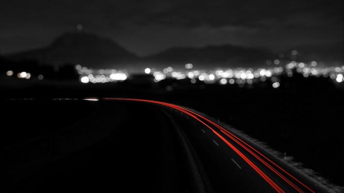 Night road with light trails and city bokeh