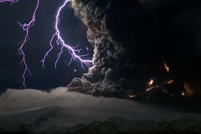 Lightning strikes a volcanic eruption with smoke and clouds