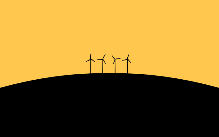 Four wind turbines on a black hill against a yellow sky