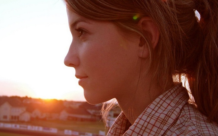 Woman in plaid shirt at sunset