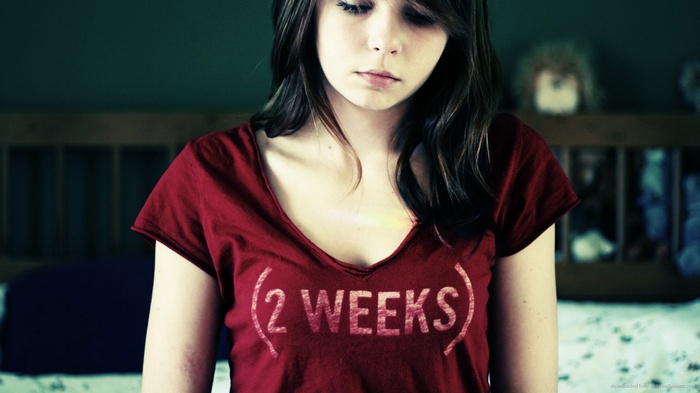Zara Jay wearing a red t-shirt with "2 WEEKS" text
