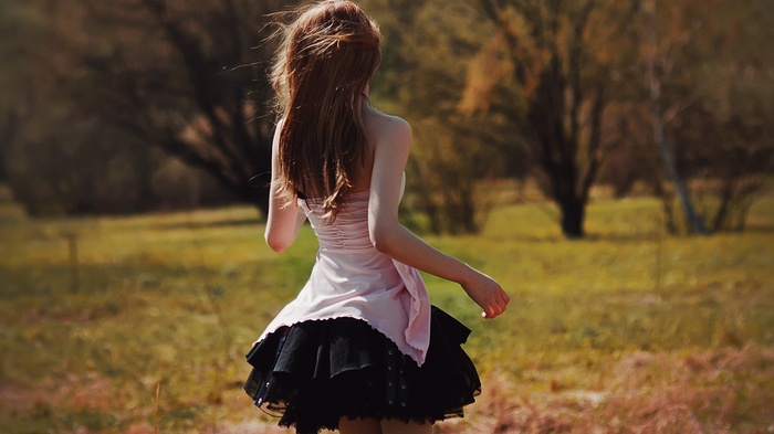 Woman in a pink and black dress in a field