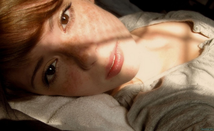 Woman with freckles lying down