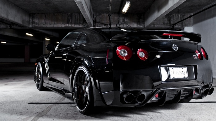 Black Nissan GT-R parked in a concrete garage