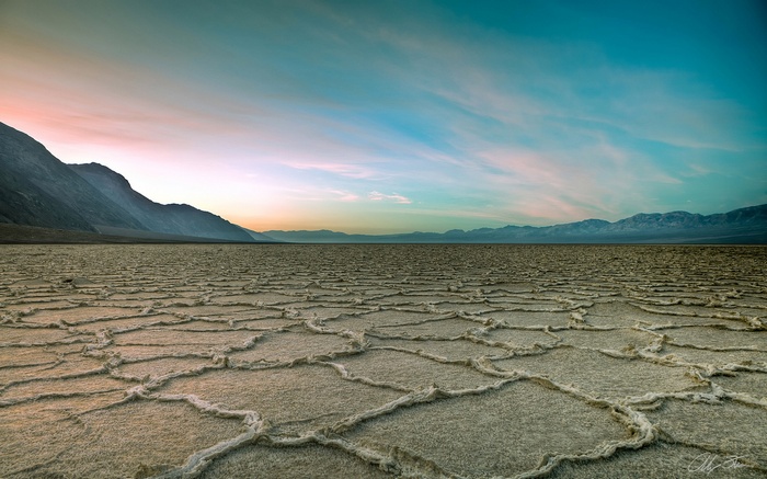Death Valley salt flats with mountains and colorful sky