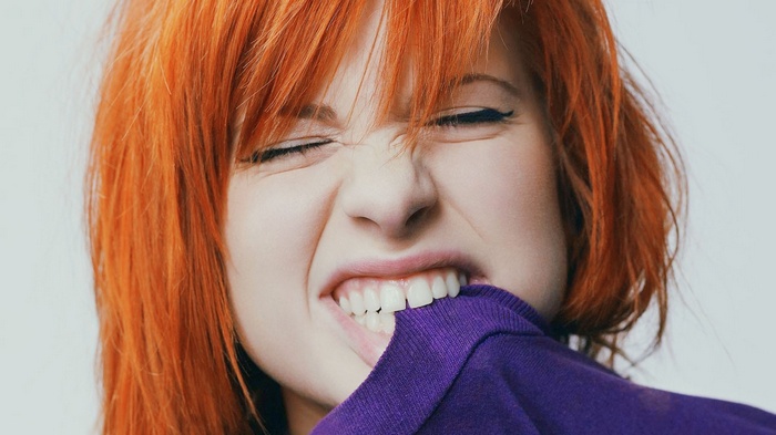 Hayley Williams with orange hair biting purple shirt