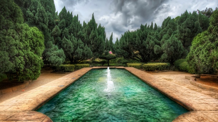 Rectangular pool with fountain surrounded by trees
