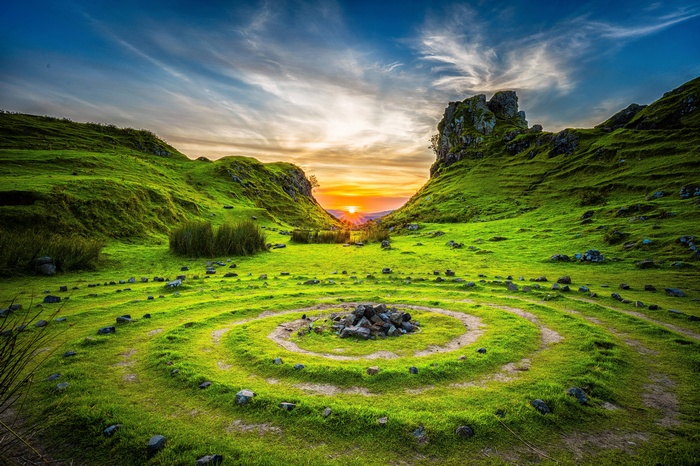 Stone circles in a green valley at sunset