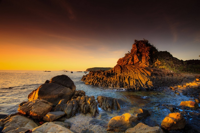 Rocky coast with basalt formations at sunset