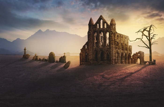 Ruined monastery and graveyard at sunset