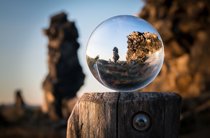 Crystal ball reflecting rock formations on a wooden post
