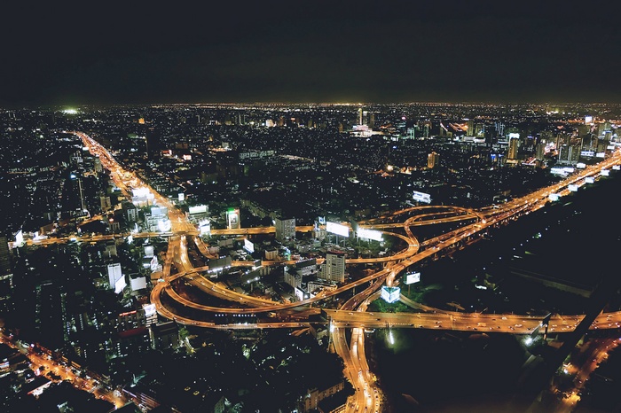 Aerial view of a city at night with a highway interchange