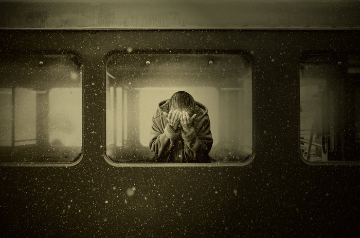 Woman crying in a train compartment during snowfall