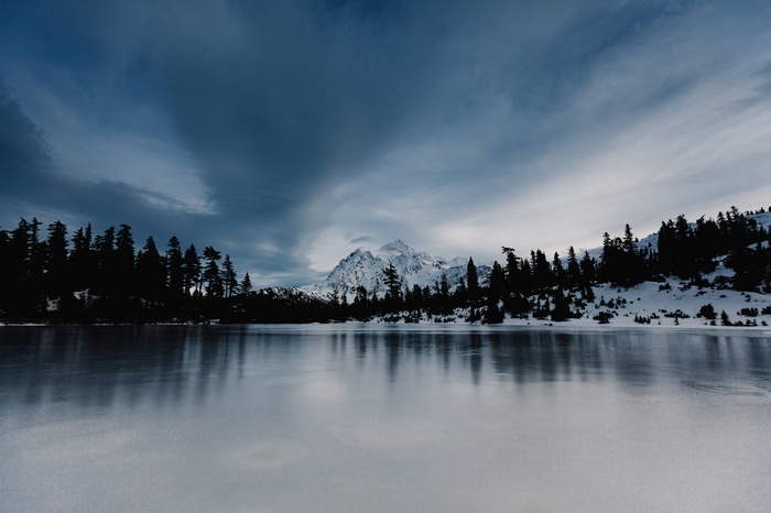 Snowy mountain range reflected in a frozen lake