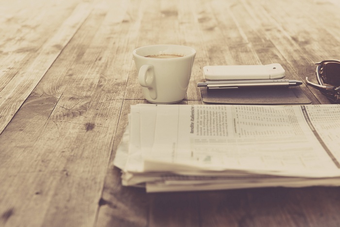Coffee and newspaper on a wooden table