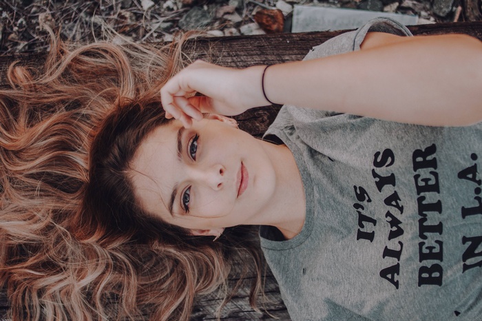 Young woman lying down with long wavy hair