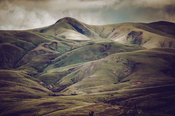 Rolling green hills under a cloudy sky