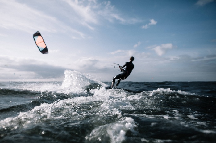 Kitesurfer riding waves on a cloudy day