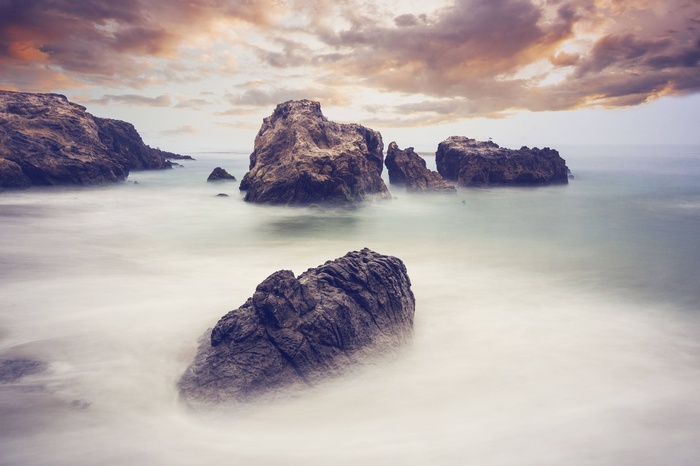 Rocks in the ocean with dramatic clouds