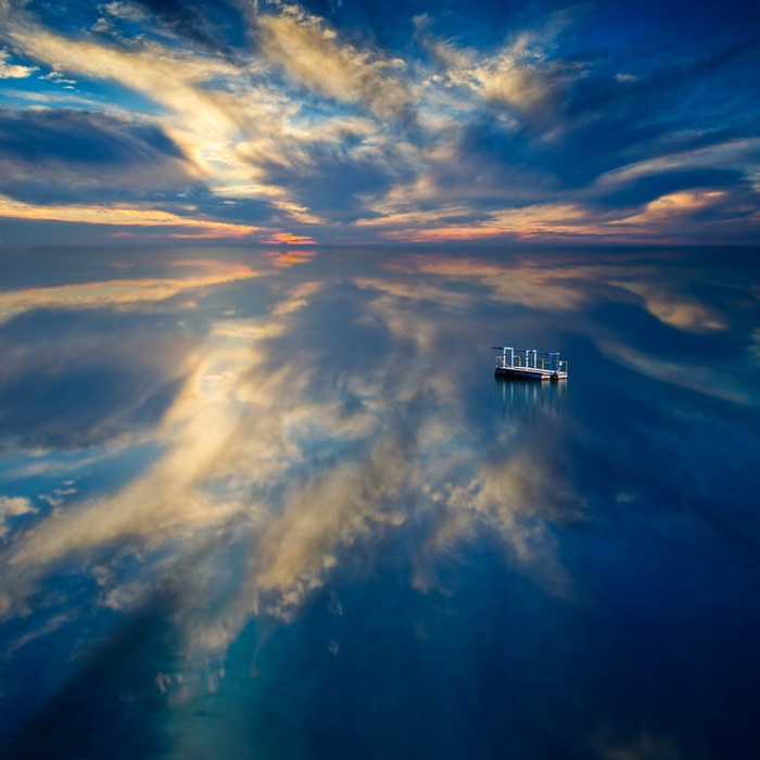 Floating platform on a reflective body of water at sunset