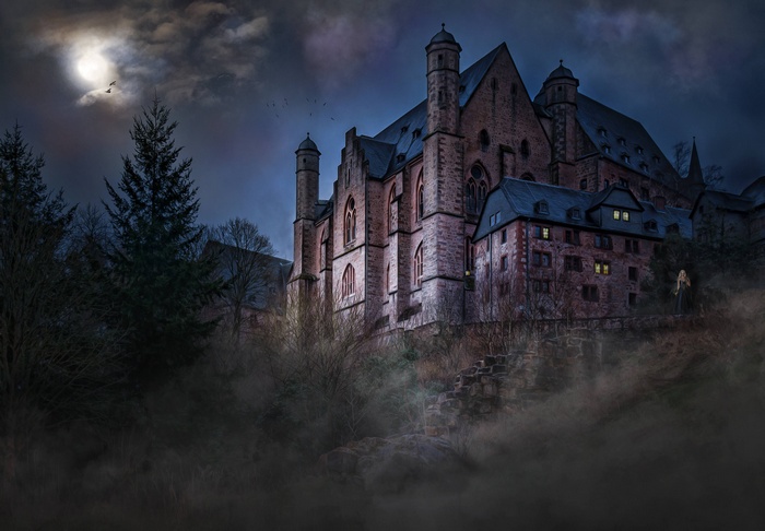 Haunted castle at night under a full moon