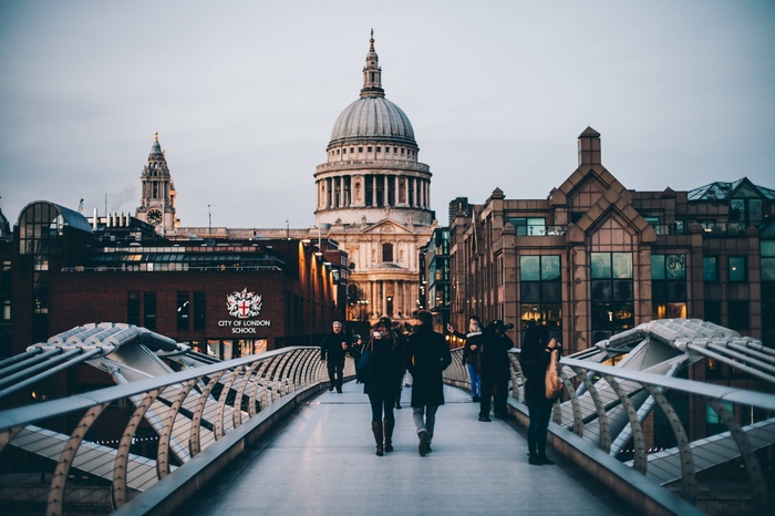 People walking on Millennium Bridge towards St. Paul's Cathedral in London