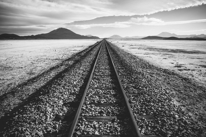 Railroad tracks stretching into the distance across a barren landscape