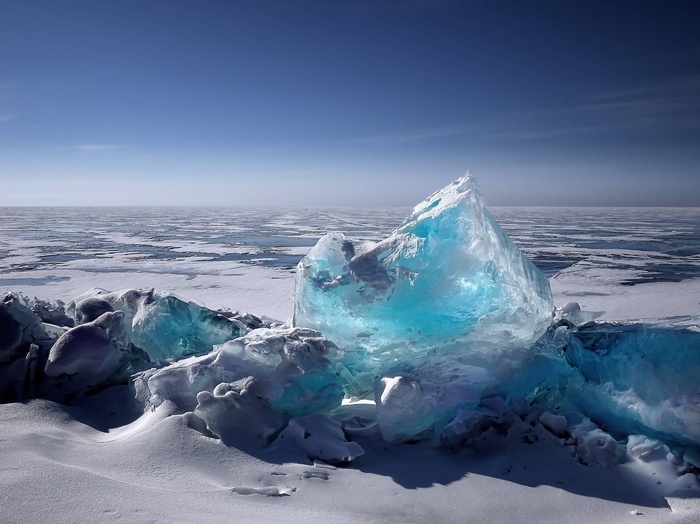Blue ice formations on a frozen landscape under a clear sky