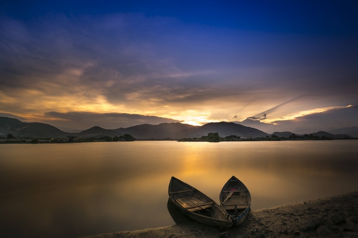 Two boats on the shore at sunset