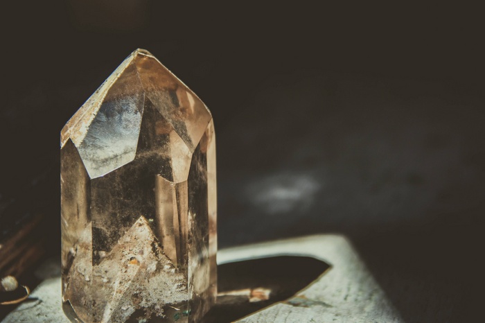 Close-up of a smoky quartz crystal on a textured surface