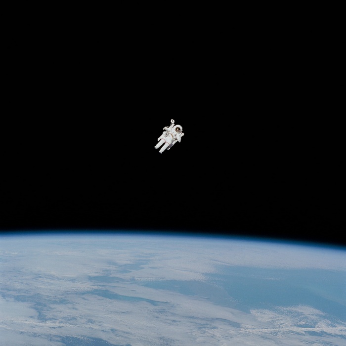 Astronaut floating in space above Earth