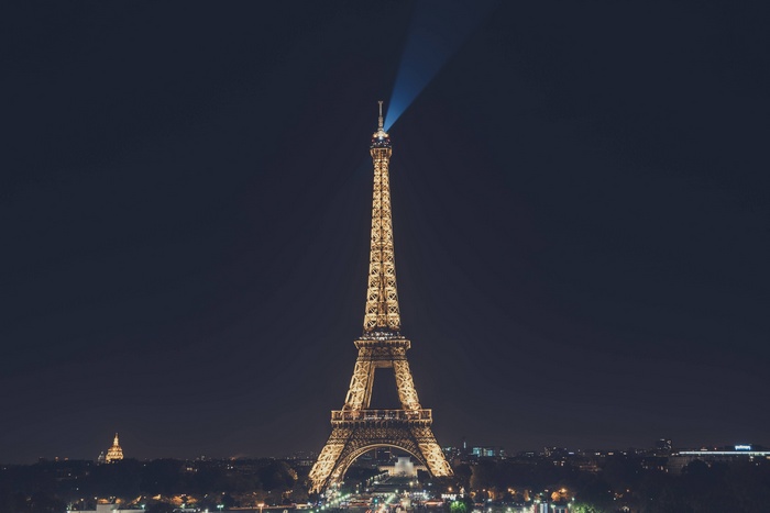 Eiffel Tower illuminated at night with a beam of light