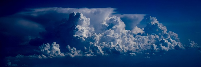 Cumulus clouds in a dark blue sky