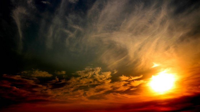 Sunset with dramatic clouds and bright sun