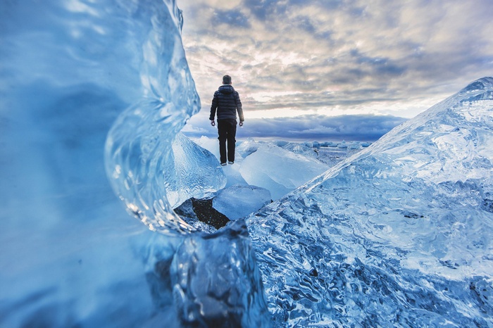 Man standing on icebergs at a glacier