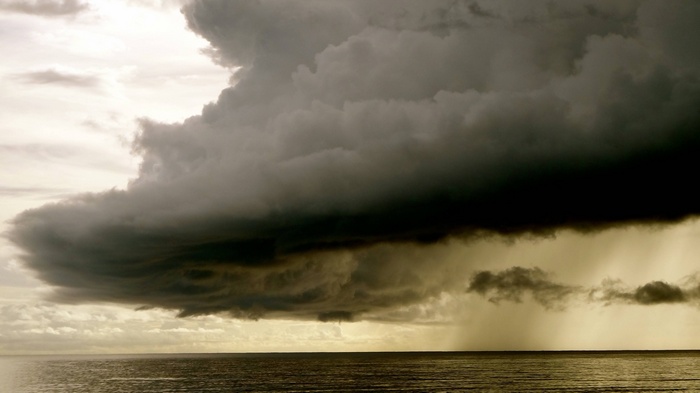Storm clouds over the ocean horizon