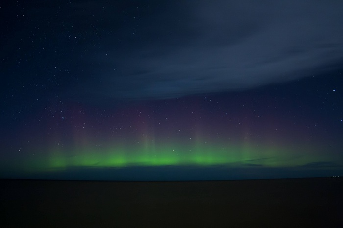 Aurora Borealis over a dark landscape