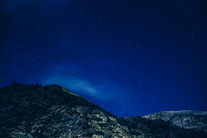 Starry night sky over rocky mountains