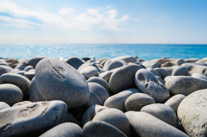 Smooth rocks on a beach with the ocean and sky