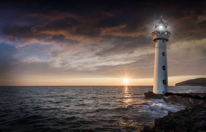 Lighthouse on the sea at sunset