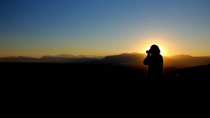 Silhouette of a photographer taking a picture at sunset
