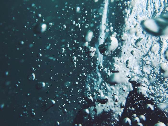 Underwater bubbles in dark blue water