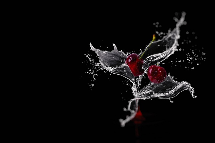 Cherries splashing in water