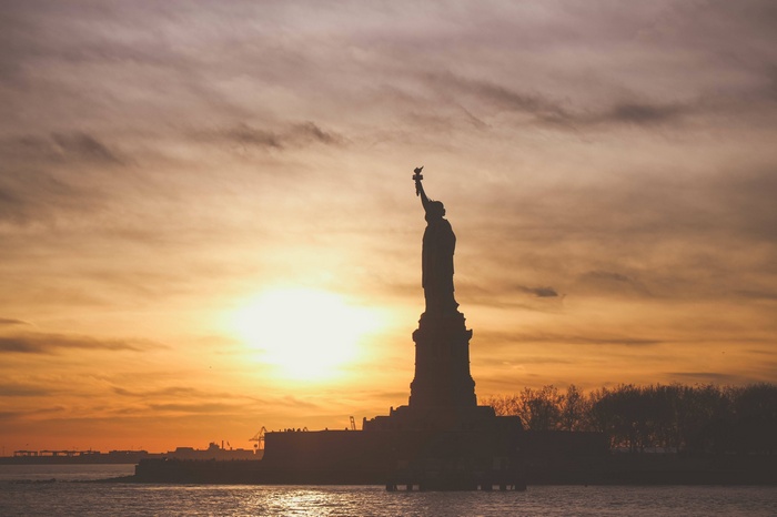 Statue of Liberty at sunset over the water