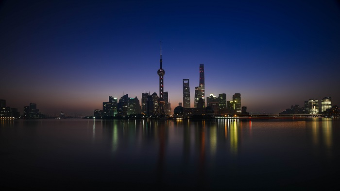 Shanghai skyline at night with reflections in the water