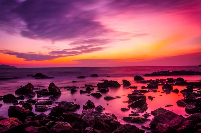 Ocean sunset with colorful clouds and rocks